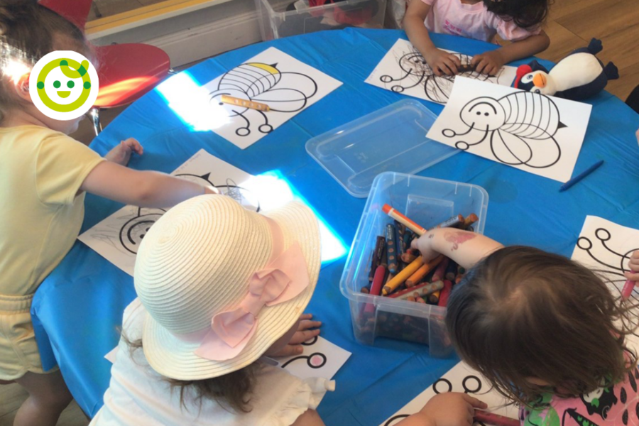 Kinder malen in der Kita kinderzimmer Hamburg gemeinsam an einem Tisch mit Ausmalbildern.