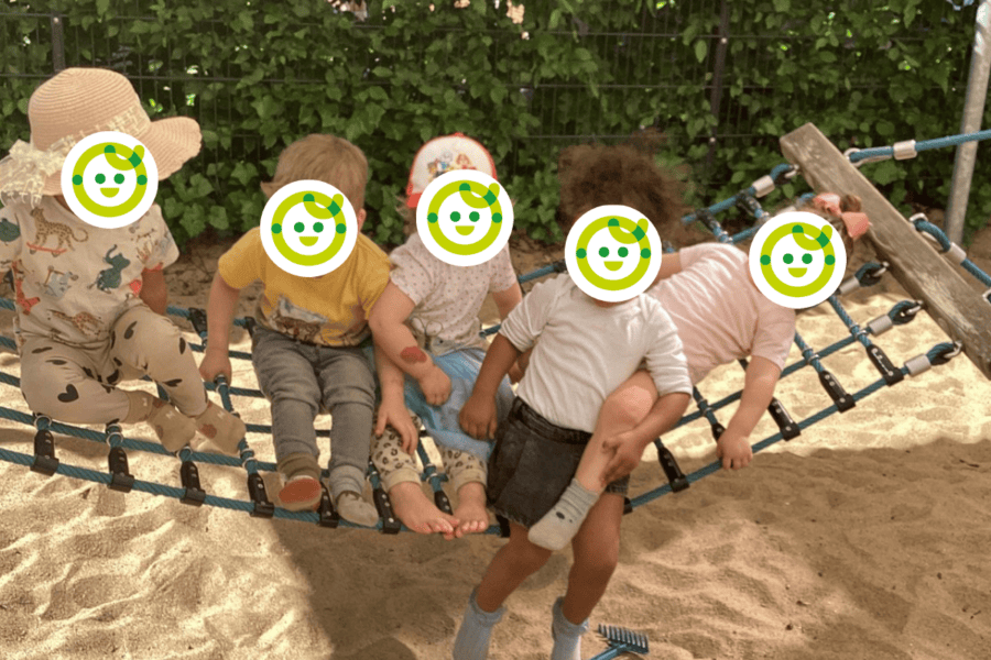 Kinder spielen im Außengelände auf einer Schaukel in der Kita Hamburg Bahrenfeld Villa Goldschmidtpark