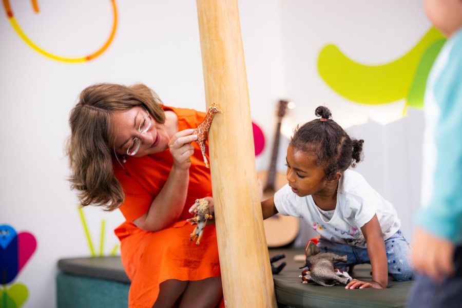 kita-kinderzimmer-hamburg-brand-shooting-olga-madchen-3x7a3789 Eine Pädagogin zeigt einem Kind eine Giraffe in der Kita kinderzimmer Hamburg