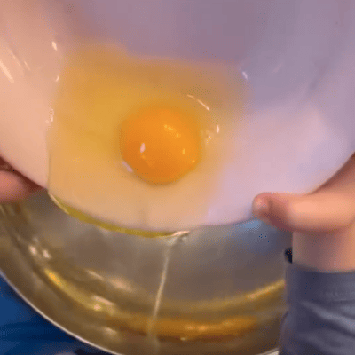 kita-kinderzimmer-eißendorf-hamburg-backen-herzhafter-kuchen-Bildschirmfoto 2024-11-12 um 10.38.35 Kinder fügen Eier zum Kuchenteig hinzu in der Kita kinderzimmer Eißendorf in Hamburg Eißendorf