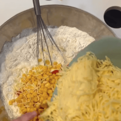 kita-kinderzimmer-eißendorf-hamburg-backen-herzhafter-kuchen-Bildschirmfoto 2024-11-12 um 10.39.44 Kinder fügen Käse zum Kuchenteig hinzu in der Kita kinderzimmer Eißendorf in Hamburg Eißendorf