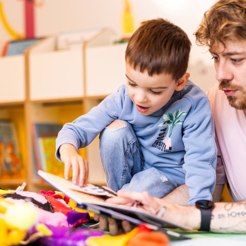 Pädagoge liest einem Jungen aus Buch vor